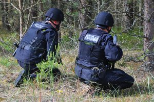 Dwaj policjanci w lesie na stanowisku obserwacyjnym.